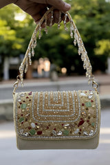 This is a luxury handcrafted clutch by the brand Slingss. It is designed as a statement piece for weddings, parties, and festive occasions.
